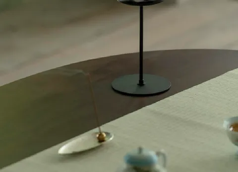 茶席一角，烛台与茶具置于木桌上。
